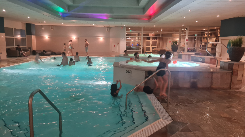 Spelende mensen in zwembad en bubbelbaden HUP Hotel